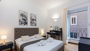 Una camera da letto ordinata con un letto grande, comodini, una scrivania e un balcone con vista.