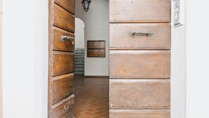 An arched doorway with wooden panels and a tiled floor. - BHR - The Window on Spoleto (Spoleto)