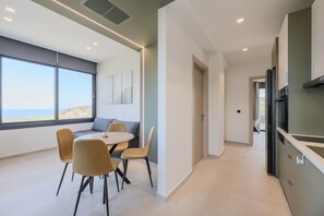 A modern kitchen with built-in appliances and a dining area with a view of the sea. - Villa Allargo - with Private Pool (Gerani)