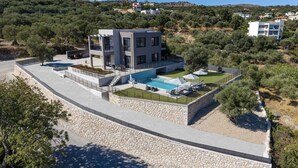 A modern two-story house with a swimming pool, stone retaining walls, and a view of the surrounding landscape. - Villa Allargo - with Private Pool (Gerani)