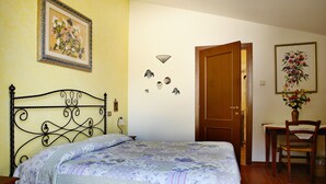 Une chambre à coucher avec un lit, un bureau, une chaise et une porte.