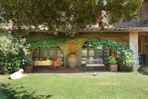 A patio with a wooden bench, a table, and potted plants. - Apartment 'Il Rovo - La Cerretola' with Shared Pool, Shared Garden and Wi-Fi (Città della Pieve)