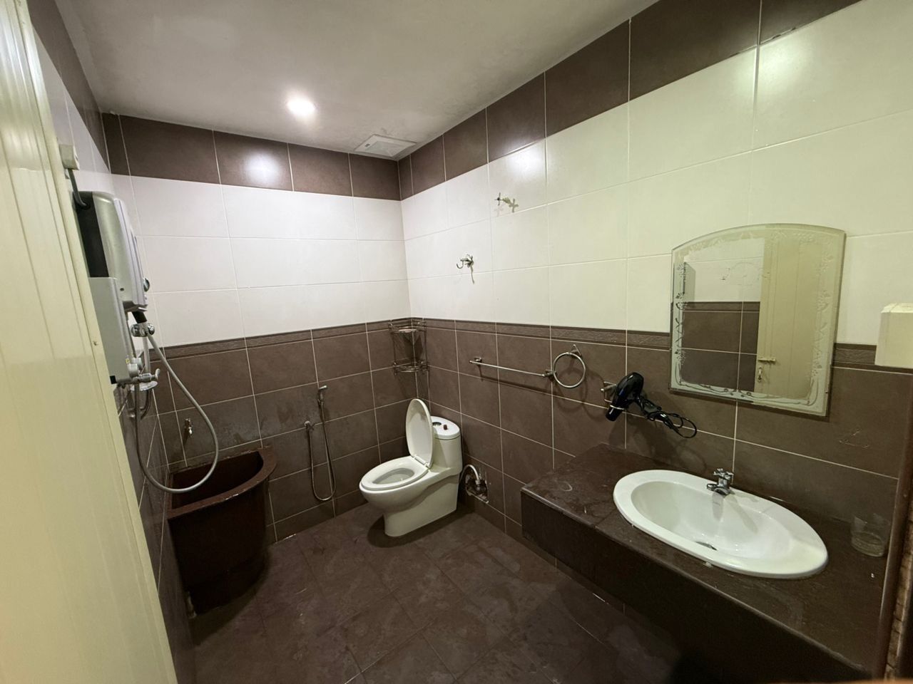 A compact bathroom with a toilet, sink, and shower.