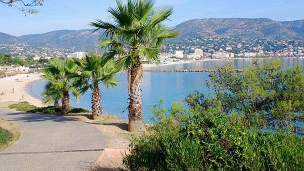 A coastal path with palm trees, a beach, and a cityscape in the background. - 3-room apartment, 5 beds with private garage in Bormes-les-Mimosas (Bormes-les-Mimosas)
