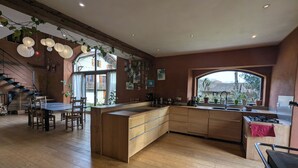 Une cuisine spacieuse dotée de meubles en bois, d’un îlot central et d’un coin repas avec des chaises.