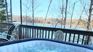 Een hottub met een houten terras en een thermometer.