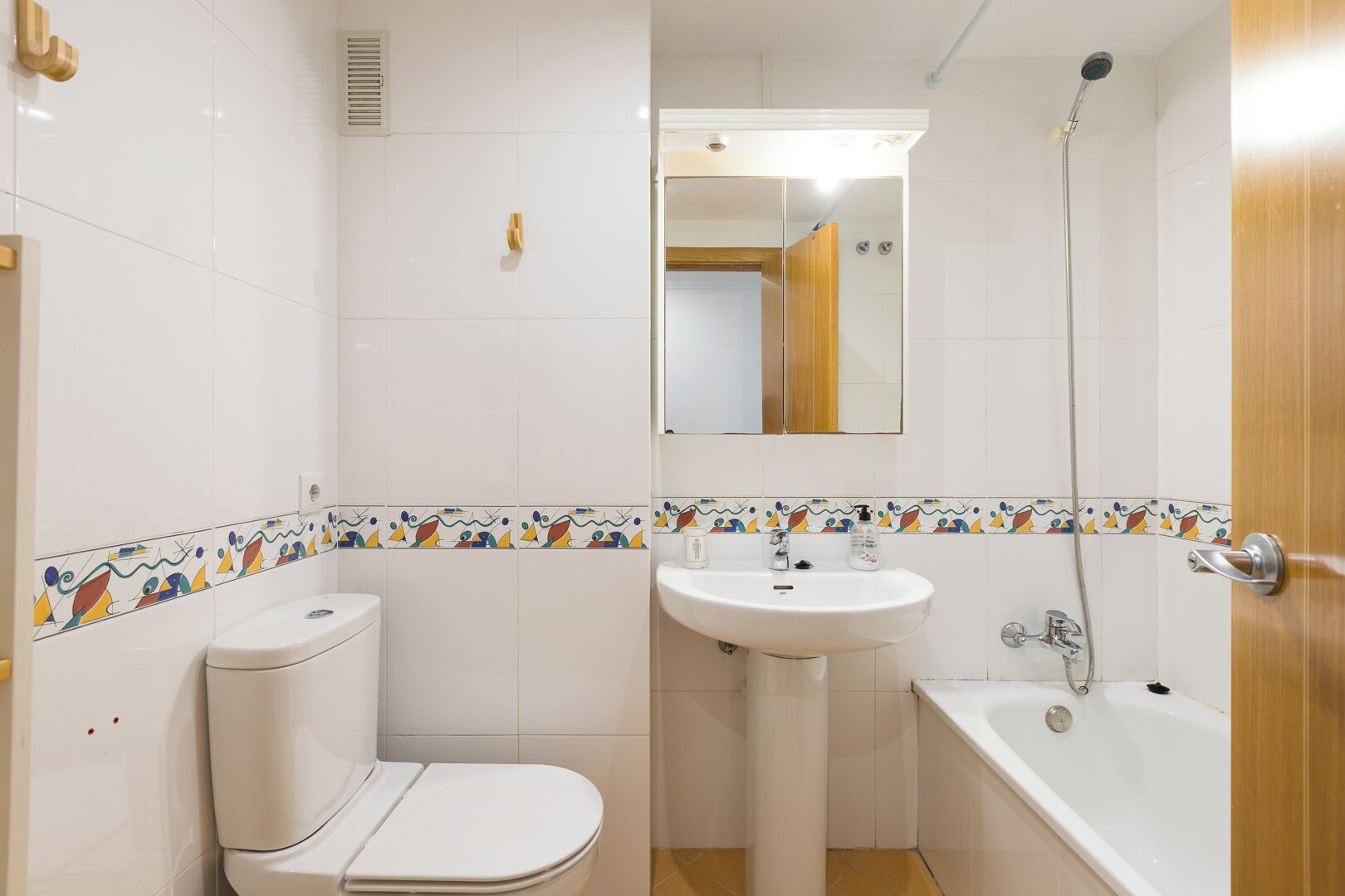 A bathroom with a toilet, sink, and bathtub.