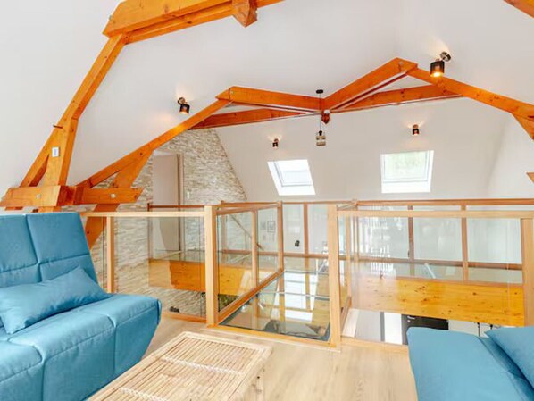 A modern loft bedroom with exposed wooden beams, a stone wall, and a glass ceiling. - Architect house with heated pool and secure park (Soulitré)
