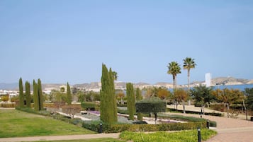 A landscaped garden with pathways, neatly trimmed hedges, and tall trees.