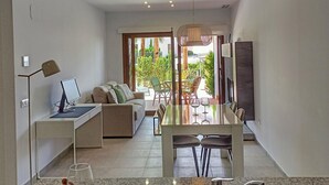 A modern kitchen with a granite countertop, a built-in sink, and a dining area with a table and chairs. - Charming apartment in San Juan de los Terreros (San Juan de los Terreros)