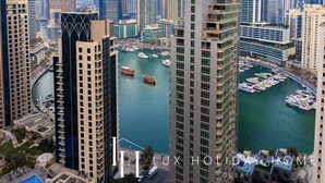 Un hotel di grandi dimensioni con vista sulla marina, caratterizzato da architettura moderna e una posizione sul lungomare.