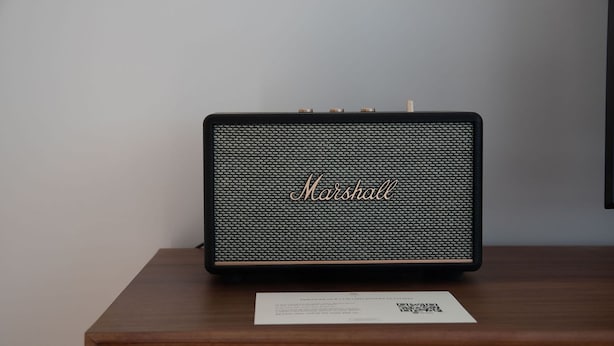 A black Marshall amplifier on a wooden table with a QR code and a white label. - Ando Living - São Miguel House - 203 (Porto)