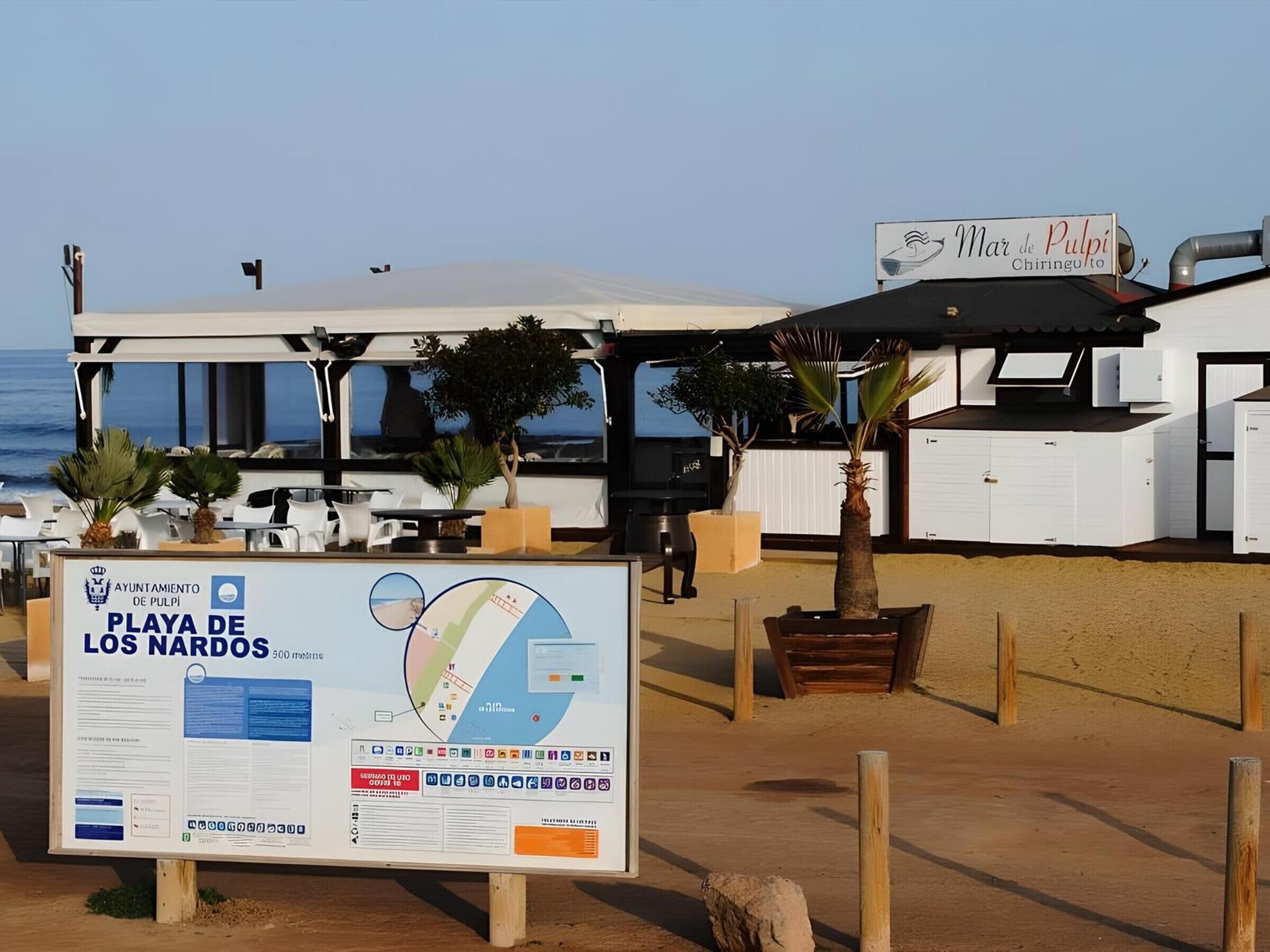 Un restaurant situé en bord de mer, appelé « Mar de Pulpi », avec une terrasse et une enseigne indiquant « Ayuntamiento de Pulpi Playa de Los Nardos ».