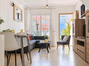 A modern living room with a dining area, a sofa, a coffee table, and a TV stand. - Cozy house in San Juan de los Terreros near the beach (San Juan de los Terreros)