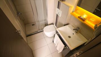 Une salle de bain moderne équipée d’une douche, de toilettes et d’un lavabo.