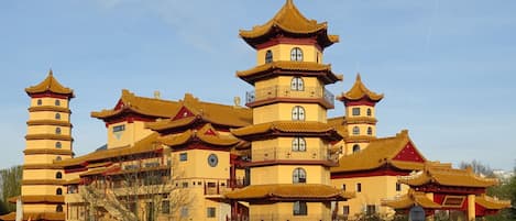 Un edificio tradicional de varios niveles, con un diseño simétrico, balcones múltiples y una torre central.