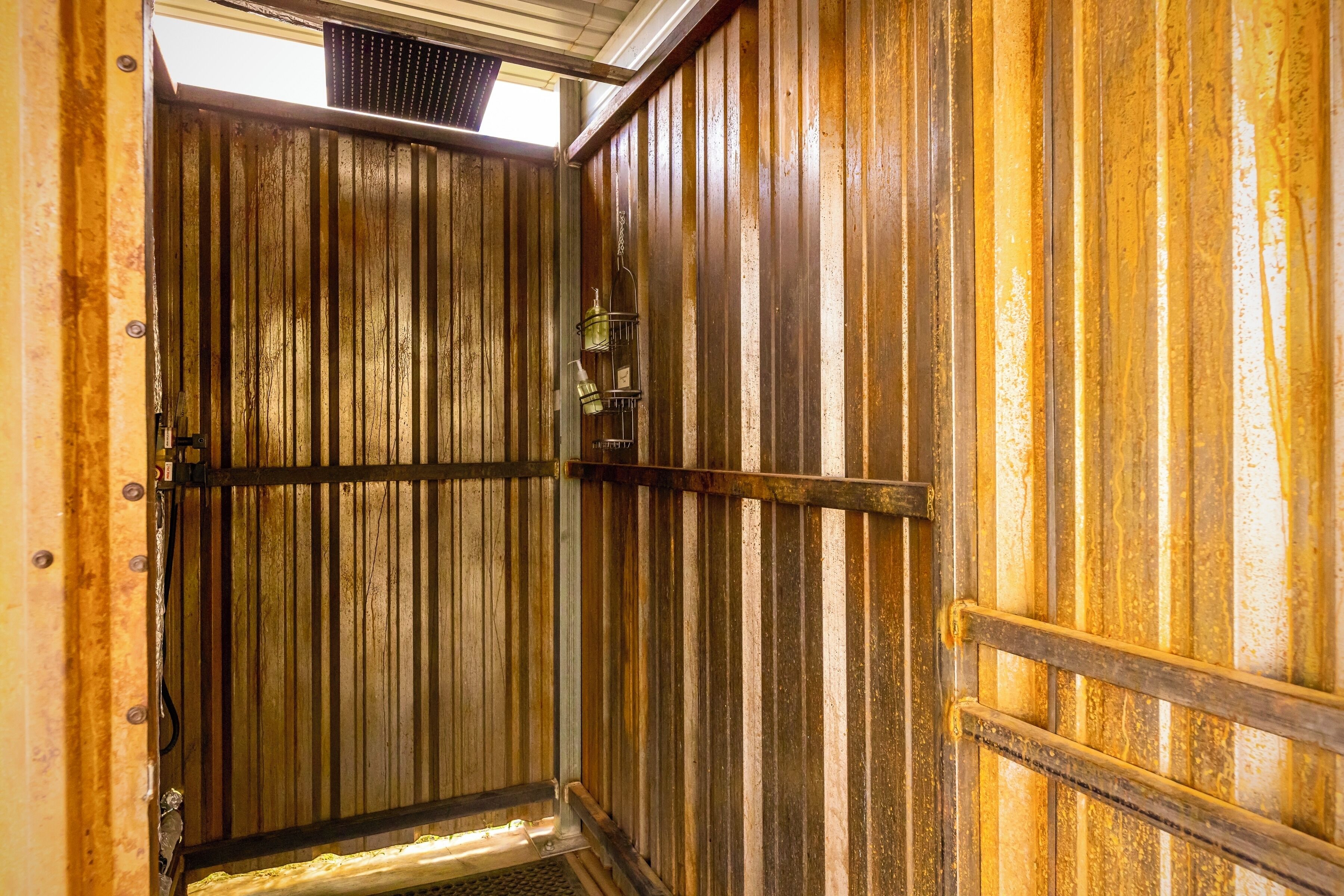 Une porte en bois avec un loquet en métal et une étagère en métal sur laquelle sont posés divers objets.