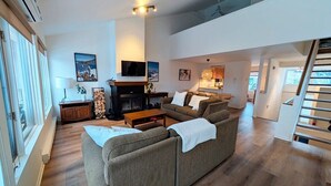 A spacious living room with a fireplace, a sofa set, and a dining area. - Unit 33 - 4 bedrooms - 10 people (Beaupré)