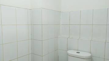 Um banheiro pequeno e limpo, com azulejos e vaso sanitário brancos.
