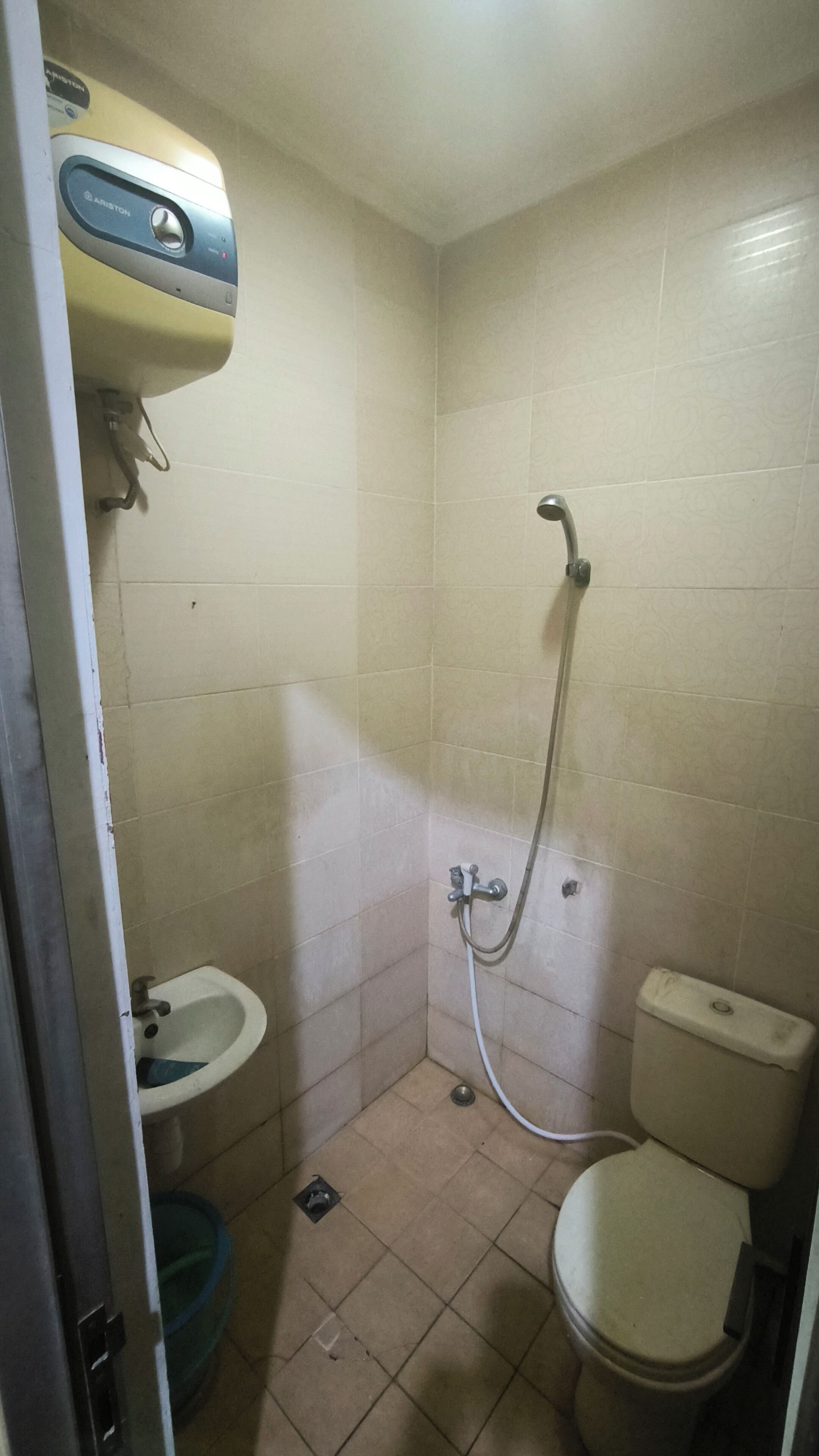 Um banheiro pequeno com azulejos, vaso sanitário, bidê e chuveiro.