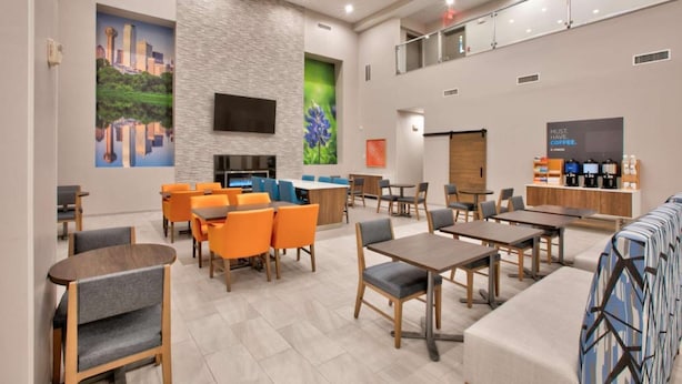 A modern hotel lobby with seating areas, a fireplace, and a coffee station. - Stay Near Galleria +  Pool & Breakfast Included (Dallas)