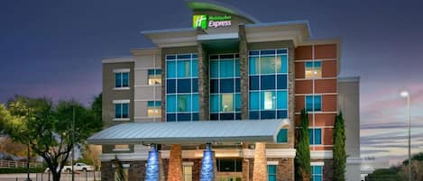 A Holiday Inn Express hotel with a modern design, featuring large windows and a prominent entrance.