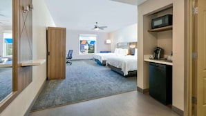 A hotel room with two beds, a desk, a microwave, and a coffee maker. - Stay Near Galleria +  Pool & Breakfast Included (Dallas)