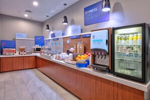 A breakfast area with a self-serve station, a yogurt dispenser, and a refrigerator stocked with beverages. - Standard 2 Queen Room w/ Fridge | Pool. Gym. Wi-Fi (Dallas)