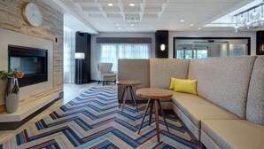 A modern living room with a sofa, two small tables, a TV, and a patterned rug. - Near Ridge Hill shopping. Breakfast. Pool. Bar. (Yonkers)