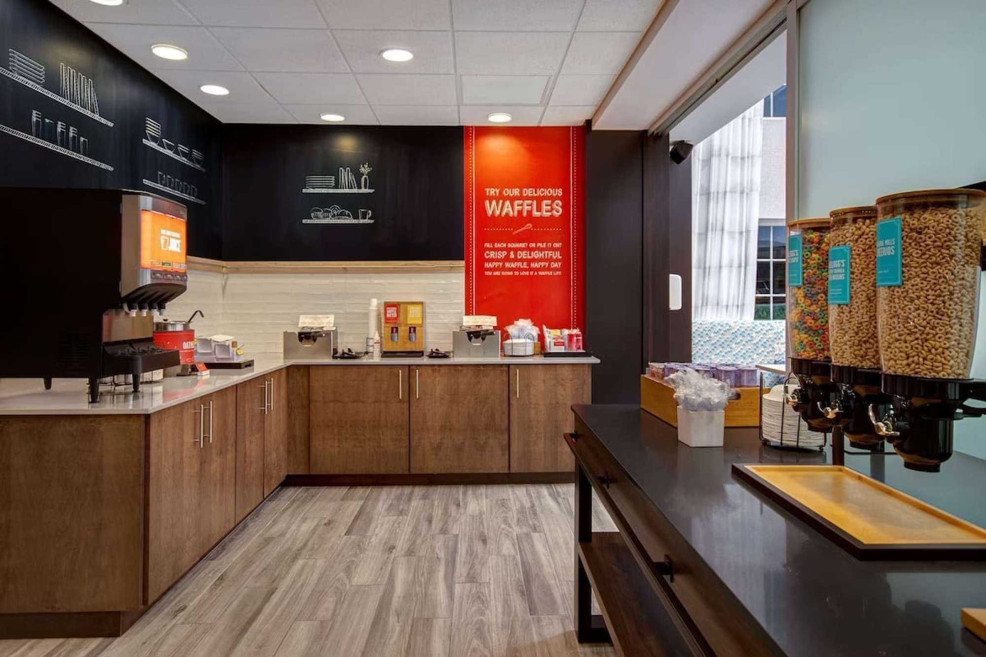 Een moderne keukenhoek met een koffieapparaat, een pannenkoekenstation en een aanrecht met diverse spullen.
