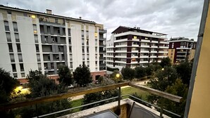 A balcony with a table and chairs, overlooking a residential area with multi-story buildings. - Félicità T2 - Swimming pool - Parking - Netflix - 15 minutes walk from downtown (Toulouse)