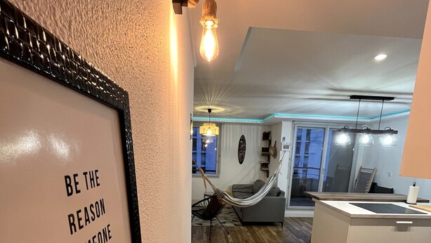 A modern interior with a wooden floor, a framed inspirational quote, a hammock, and a dining area with a large table. - Félicità T2 - Swimming pool - Parking - Netflix - 15 minutes walk from downtown (Toulouse)