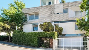 A modern two-story house with a flat roof, large windows, and a gated driveway. - Elegant Fresnaye Ocean View 4bed Nerine Manor (Cape Town)