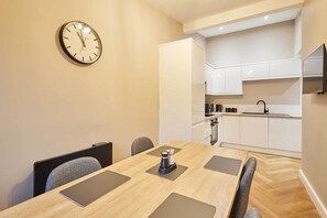Una cocina moderna con armarios blancos, un grifo negro y un reloj en la pared.