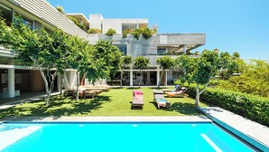 A modern house with a swimming pool, outdoor seating, and lush greenery. - Opulent Spacious Fresnaye Sea View Leonotis Villa (Cape Town)