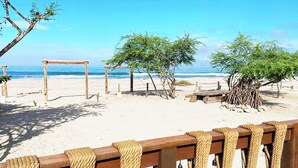 A beach with wooden structures and rope barriers.