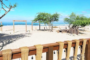 Una playa con estructuras de madera y barreras de cuerda.