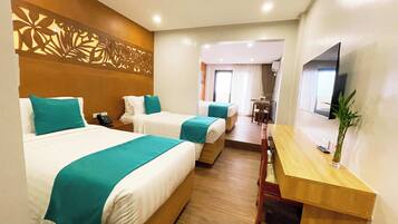 A hotel room with two beds, a desk, a TV, and a decorative wall panel.