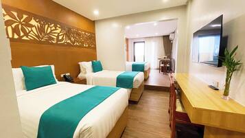 Deluxe Quadruple Room | Escritorio y ropa de cama