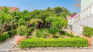 A garden with various plants and a staircase leading to a building. - Holiday Home Florendale with pool (Maslenica)