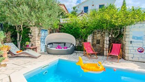 A swimming pool with lounge chairs and a fish float. - Holiday Home Florendale with pool (Maslenica)
