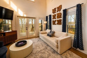 Una sala de estar con un sofá, una mesa de centro, un televisor y una pared decorada con obras de arte de madera.