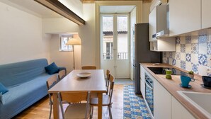 A compact kitchen with a dining table, chairs, a sofa, and a tiled backsplash. - GuestHost - Charming and cozy 91 square meters apartment, perfect for four people, located on the first floor of the historic Palazzo Auteri Perrotta (NO elevator).Elegantly decorated, it features two frescoed ceilings.The property is located in the hear (Catania)