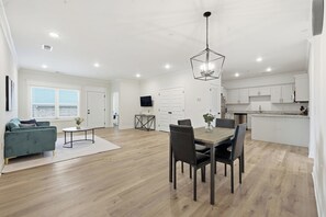 Un appartement moderne comprenant un coin repas, une cuisine et un salon.