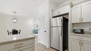 A modern kitchen with white cabinetry, stainless steel appliances, and a granite countertop. - Relaxing 2BR Home w/ Contemporary Style (Madison)