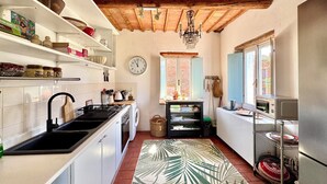 A kitchen with white cabinets, a black stove, and a wooden ceiling. - Lovely Apartment with Breathtaking Views in Cool Umbrian Village (Gioiella)