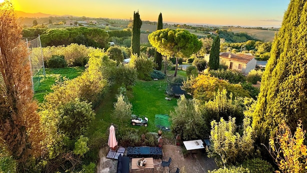 A garden with a patio, a lawn, and a view of the countryside. - Lovely Apartment with Breathtaking Views in Cool Umbrian Village (Gioiella)