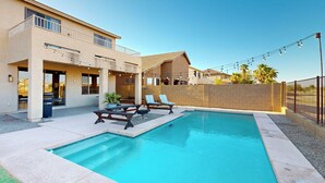 Propiedad residencial con piscina, mobiliario exterior y balcón.