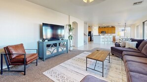Una sala de estar moderna con un sofá, una mesa de centro y un televisor sobre un mueble.