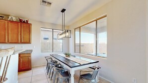 Una cocina moderna con una isla grande, armarios de madera y vistas al exterior.